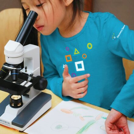 Discovery Center Kid looking through Microscope